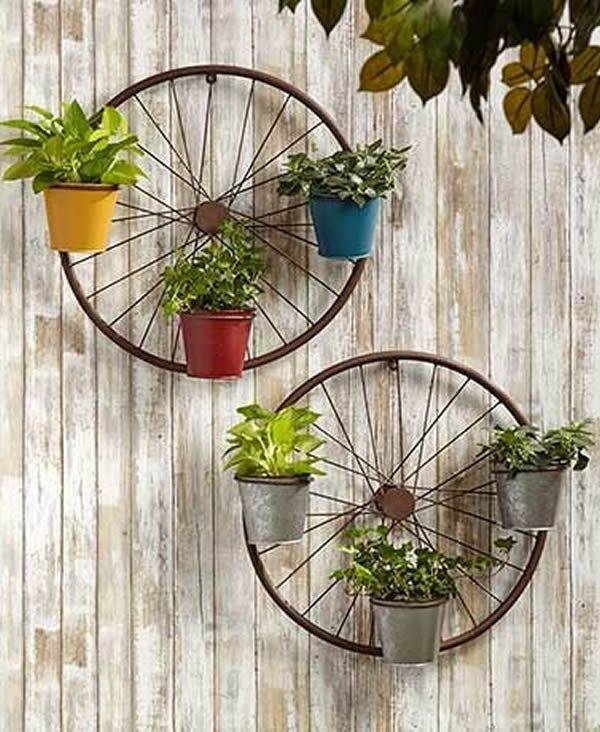 Thinking about garden decoration, we see various ornaments, including items that can be repurposed as happened with these bicycle wheels, which are now used as plant holders.