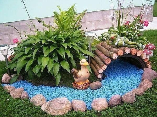 Create a special space for your garden ornaments, which can resemble other elements. In this case, blue stones were used to symbolize a river.