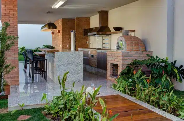 Churrasqueira gourmet rústica, com tijolos e pedras naturais.