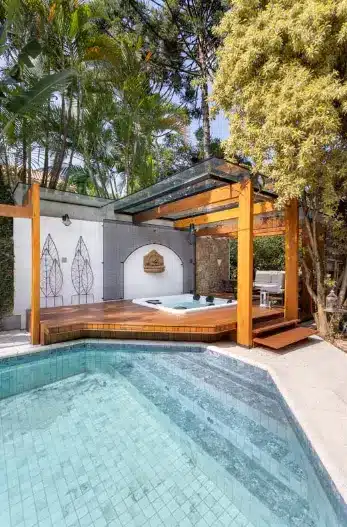 A wooden pergola in the external area with a jacuzzi and pool – Project: Rafaella Grasnoff – Loft 7 Arquitetura | Photo: Dam Mol