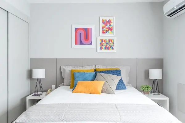 Parede e móveis brancos compõem a decoração de quarto simples de casal. Projeto de Renata Romeiro.