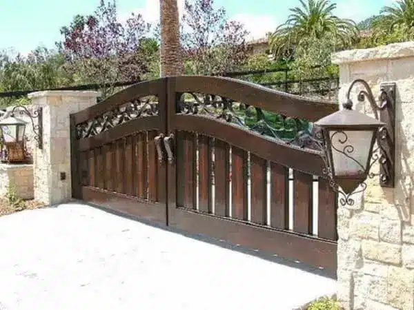 Portão de entrada de chácara feito de madeira.