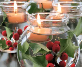 Arranjos de natal em vasos de vidro com flores e água