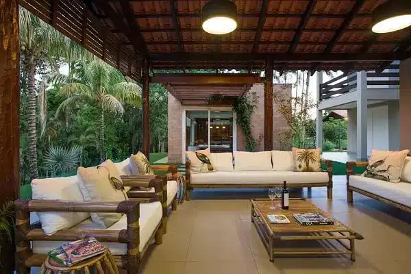 Varanda com móveis claros na casa de chácara.