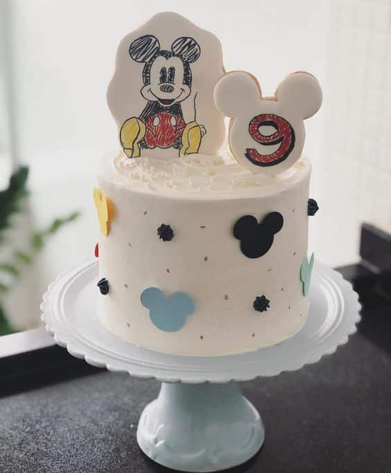 To bring a little Disney to this birthday, Mickey appears in the decoration of this fondant cake with an edible cookie topper!