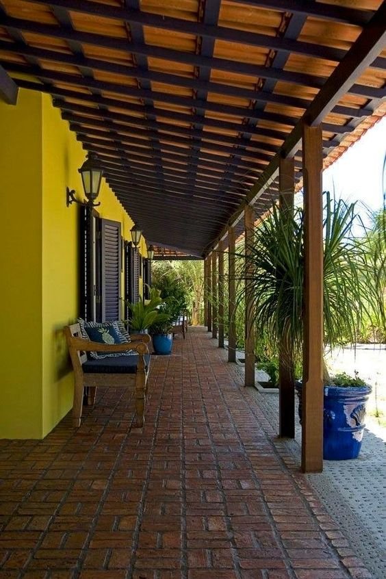 The sheltered porch area is furnished with sofas and chairs, making it a family and guest gathering space.