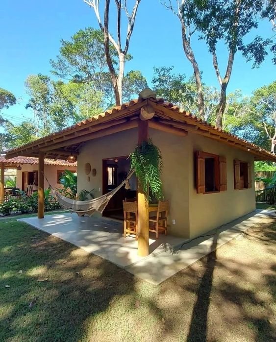 A small house with a porch mainly on the facade, with roof extension on the sides and back, illustrates effective space use.