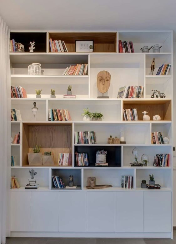 16. Nessa imagem, vemos bem como uma estante pode ser organizada para termos uma biblioteca e ao mesmo tempo incluir elementos decorativos, gerando ligação e harmonia entre os itens.