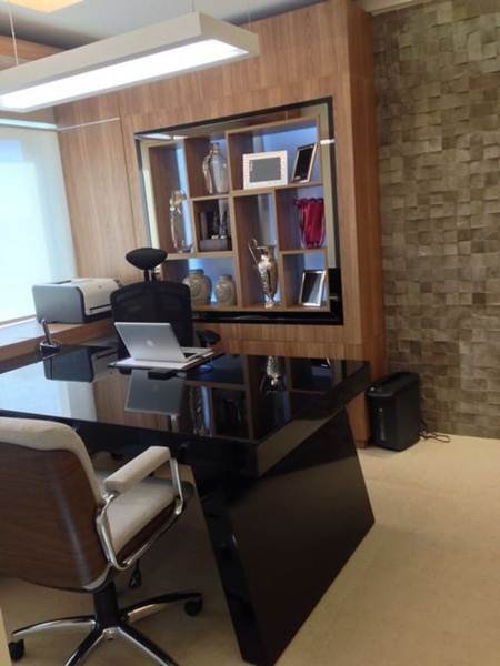 In this small office, every element grabs attention: the black table with a modern design, the stone wall, the built-in wood shelf, and the style of the chairs. Despite the limited space, the chosen elements were fundamental in creating a bold and striking environment.