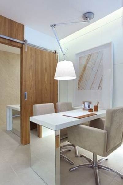 Mirrored furniture adds sophistication and elegance. In this small office, the retractable lamp and the sliding wooden door stand out, helping to save space and adding even more charm to the place.