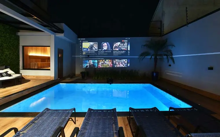 Image of a spacious and charming outdoor gourmet area set up for cooking and socializing, with a table set for dining and comfortable seating areas.