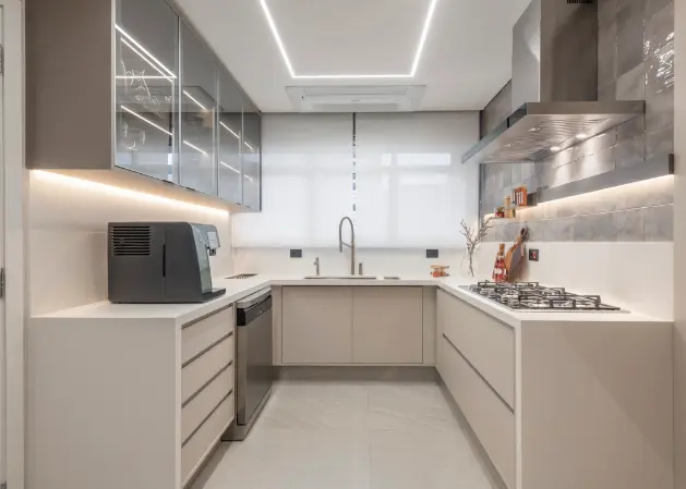 Stainless steel appliances, gray cladding, and special lighting design make this kitchen bright, spacious, and modern – Project: Patricia Hagobian | Photo: Raul Fonseca