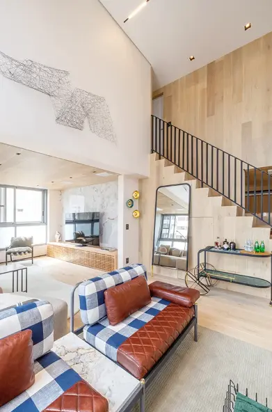 The navy blue and white checkered sofa adds a classic touch to the apartment with modern decor – Project: Yannick Athia Architecture | Photo: @maxfahrerfotografia