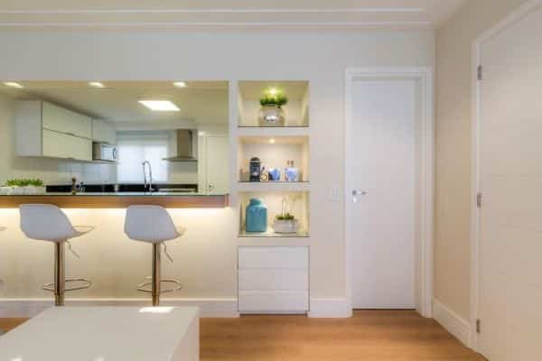 Plaster wall with niches that serves as a partition for the living room and kitchen.