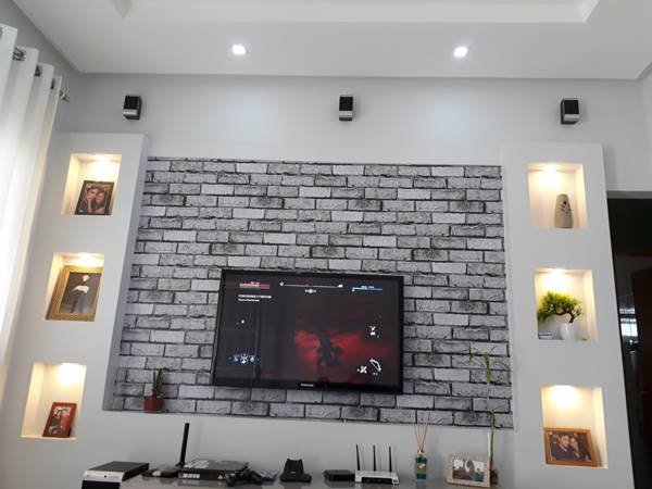 In the living room, the plaster wall supports a TV panel and also serves as a decorative base for it.