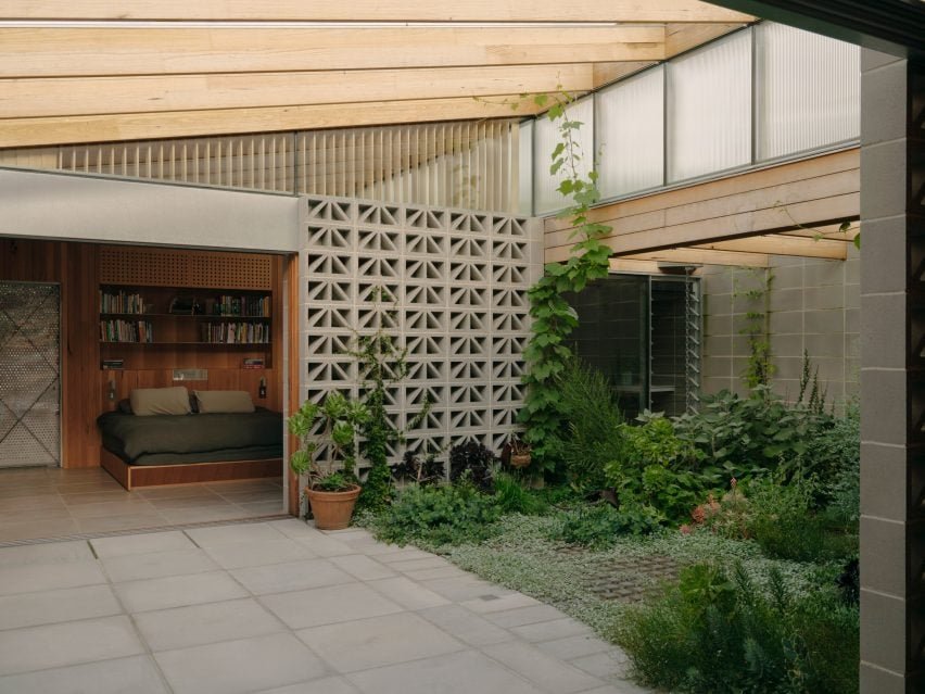 Garden courtyard surrounded by breeze block walls leading to a bedroom at the Sunday home by Architecture Architecture.