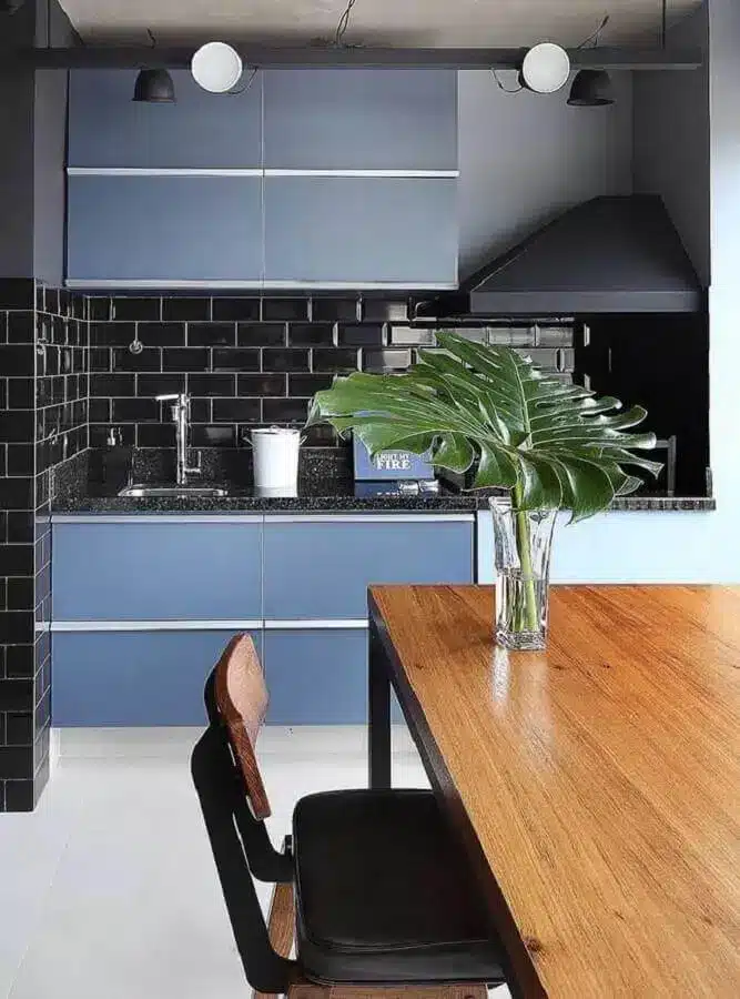 Área gourmet com armário azul petróleo e azulejo preto