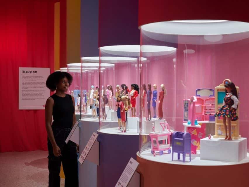 Uma seção da exposição é dedicada à evolução dos estilos de cabelo da Barbie, representados por um lustre feito de cabelo de boneca.