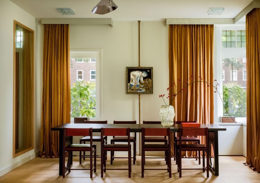 Cortinas amarelas na sala de jantar com elementos contemporâneos.
