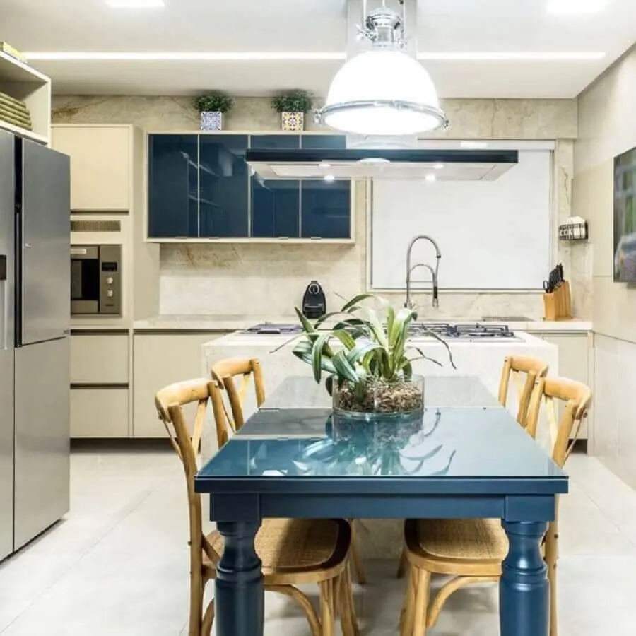 Cozinha decorada com mesa azul petróleo e cadeiras de madeira