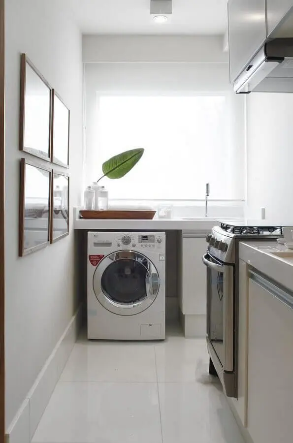 cozinha integrada com área de serviço decorada com cores claras e máquina de lavar e secar – Foto Revista VD