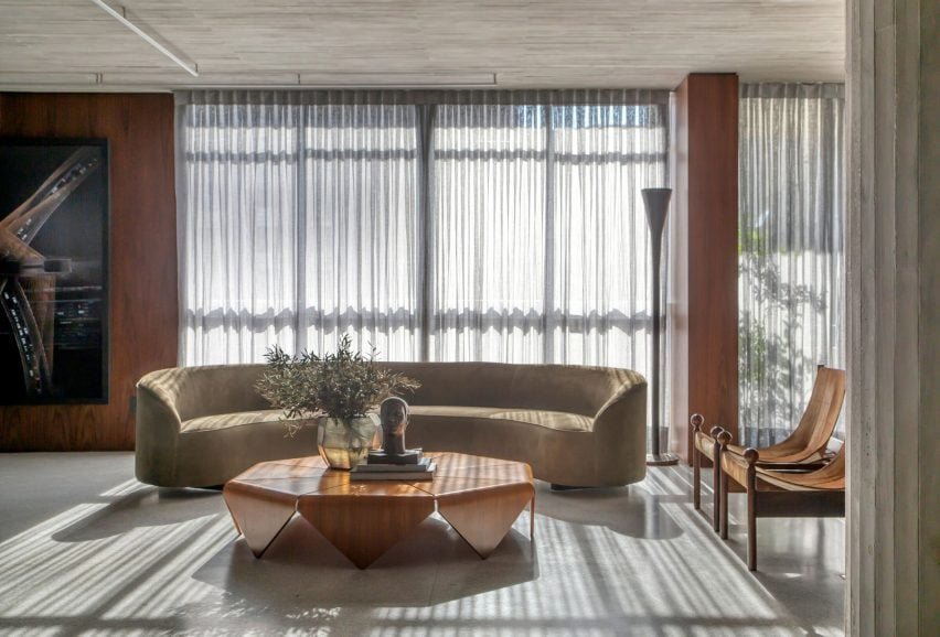 Interior of DN Apartment showcasing a sculptural center table and velvet sofa.