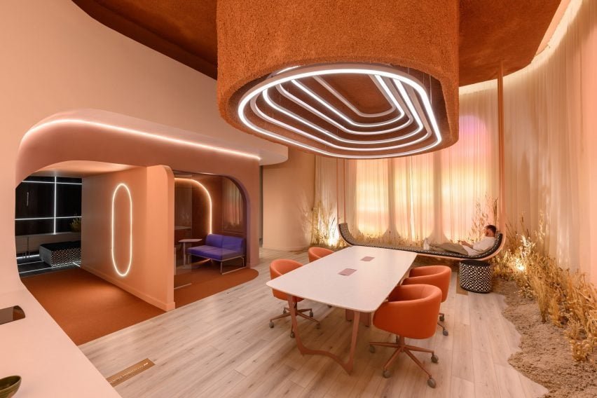 Um fixture de luz com anéis de LEDs que se destaca sobre uma mesa de jantar ou reunião.