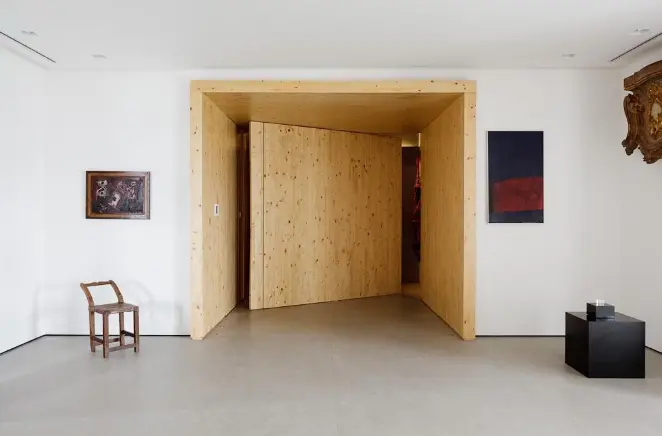 A porta de madeira pivotante traz dinamismo para a decoração – Projeto: Consuelo Jorge