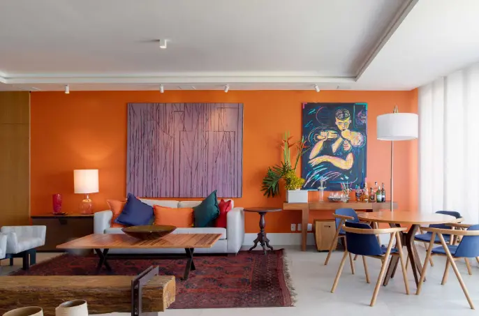 Tons de laranja e azul + almofadas coloridas + móveis de madeira – Projeto: Chicô Gouvêa – Foto: André Nazareth/CASACOR