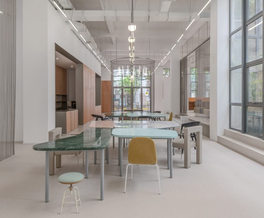 A entrada apresenta uma instalação de assento circular envolta em cortinas metálicas.