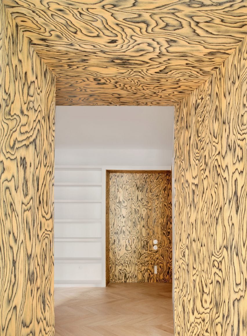 Cozinha verde suave com unidades de madeira e um tampo de inox.