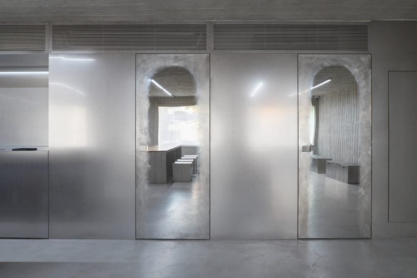 Portas de aço inoxidável que levam a uma área de armazenamento e banheiro.