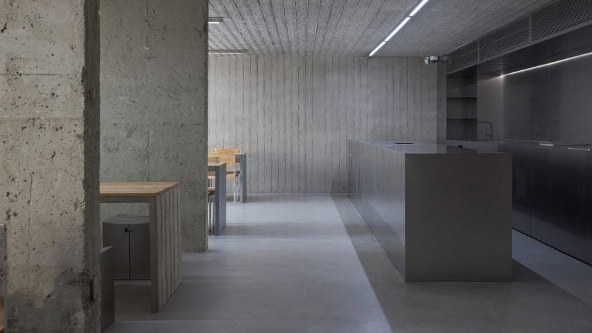 Café HaHouse em Seul com paredes de concreto e móveis em aço inoxidável com textura de madeira.