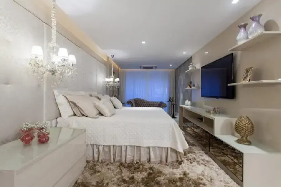 Sofisticada decoração para quarto de casal com lustre sobre criado mudo.