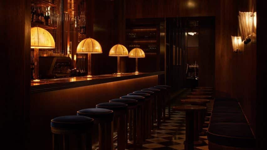Restaurant bar com lâmpadas e banquetas em um ambiente relaxante e sedutor.