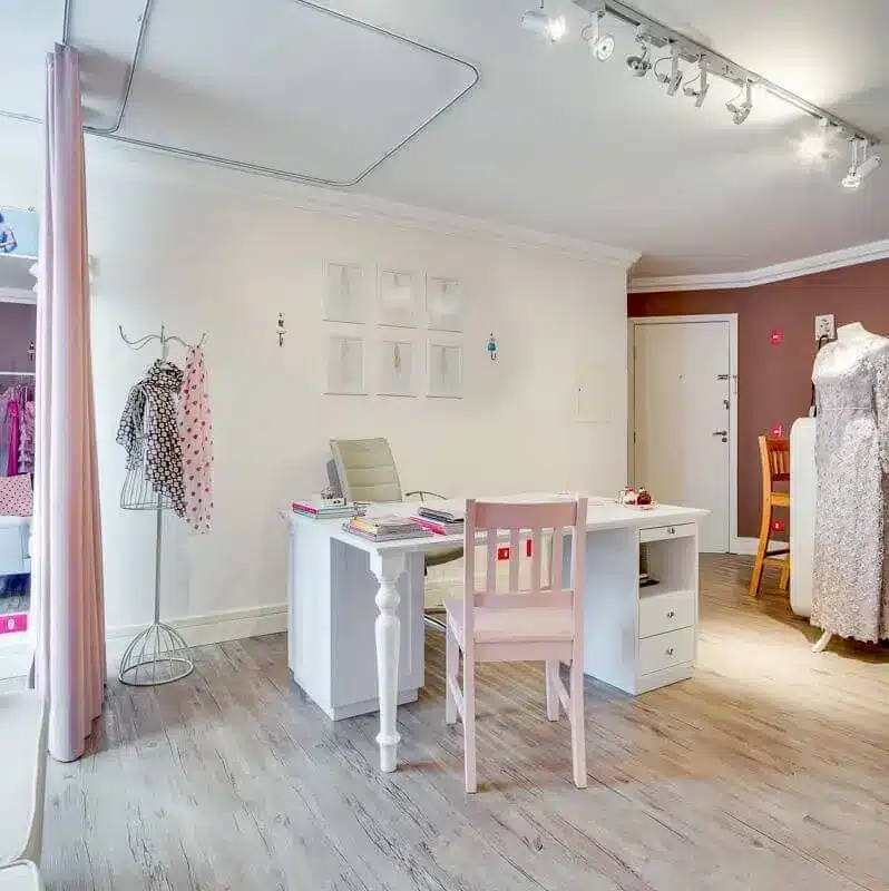 Ateliê com móveis brancos e detalhes rosa