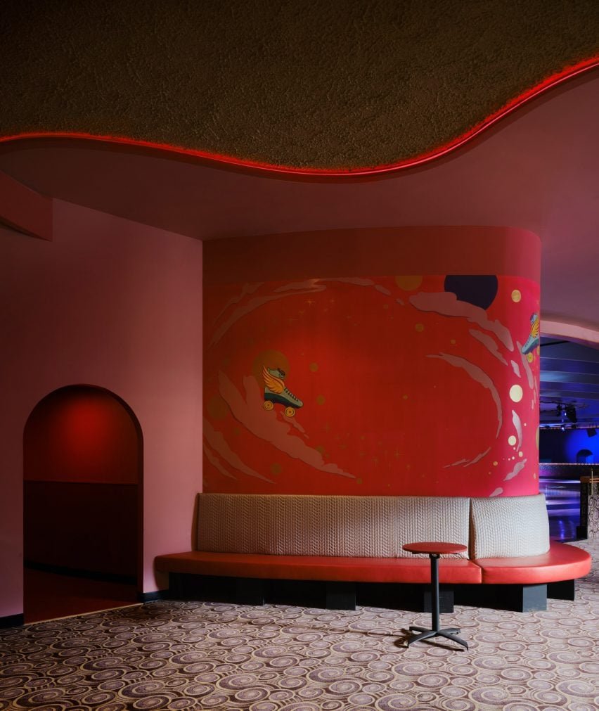 Área de banquete em Xanadu com assentos e carpete padrão opulentos.